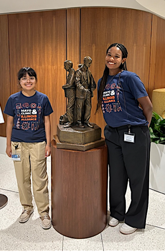 Two Illinois SURF stand in lobby with Mayo Clinic statue