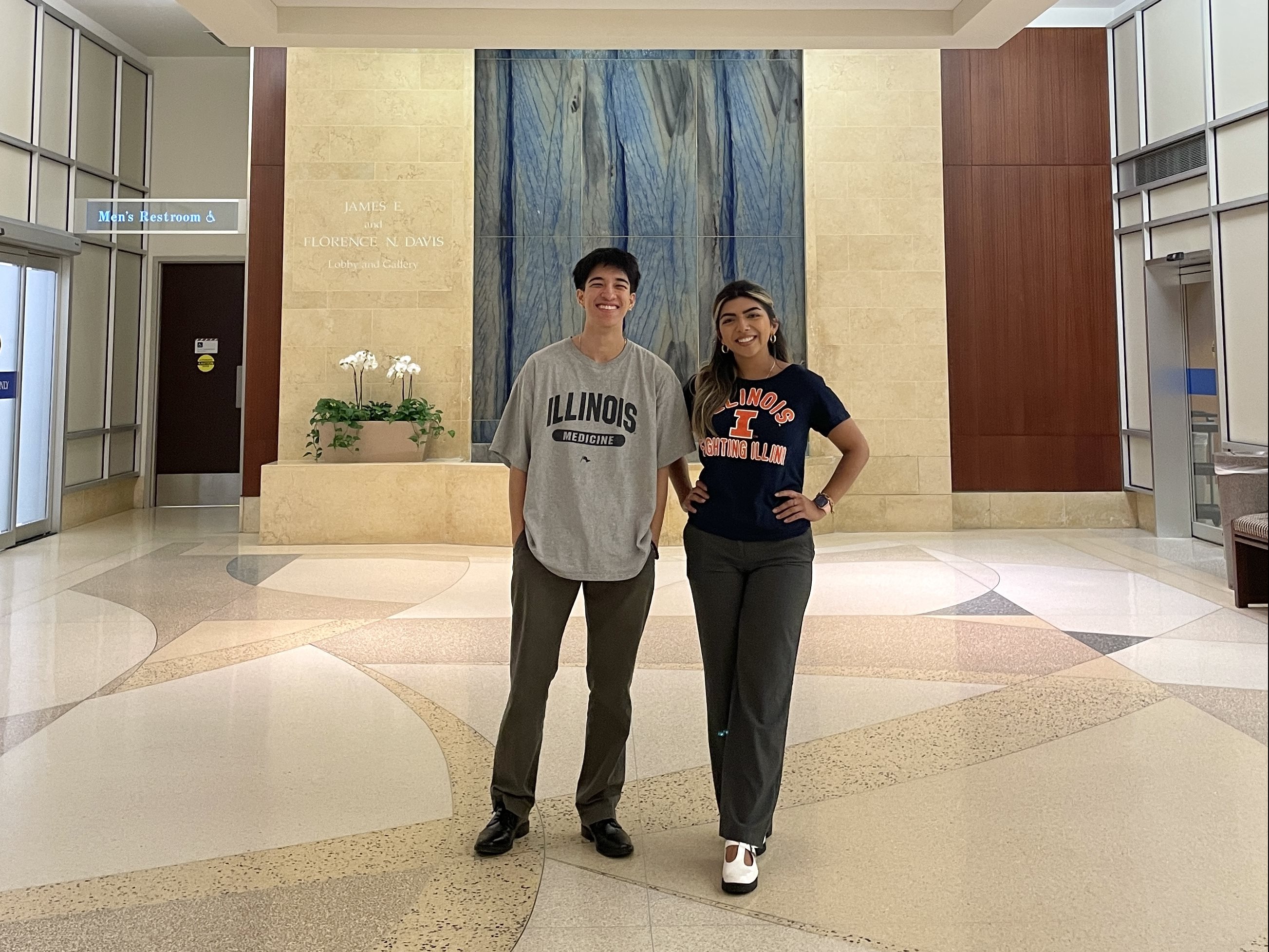 HERE Brandon and Isela standing under a colorful 3D display inside lobby at Mayo Clinic.